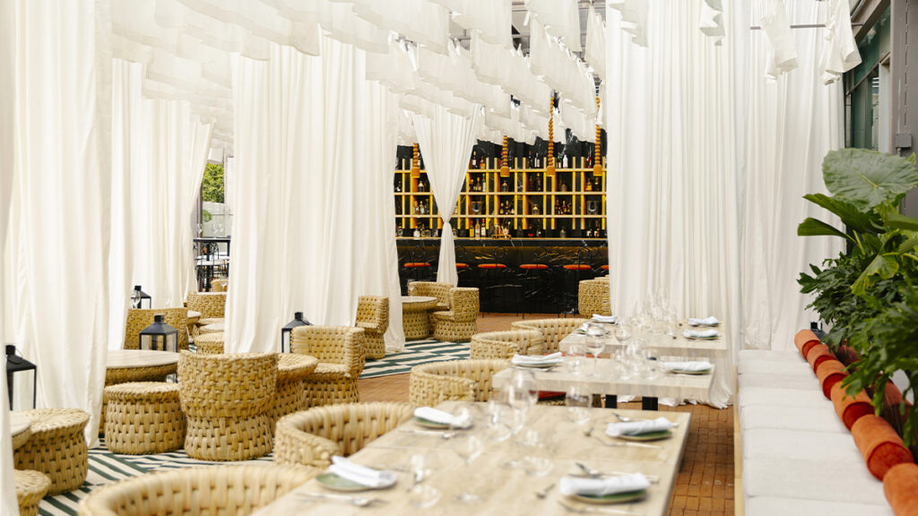 Terraza interior del Hotel W Ciudad de México con mesas de madera en un ambiente moderno y sofisticado
