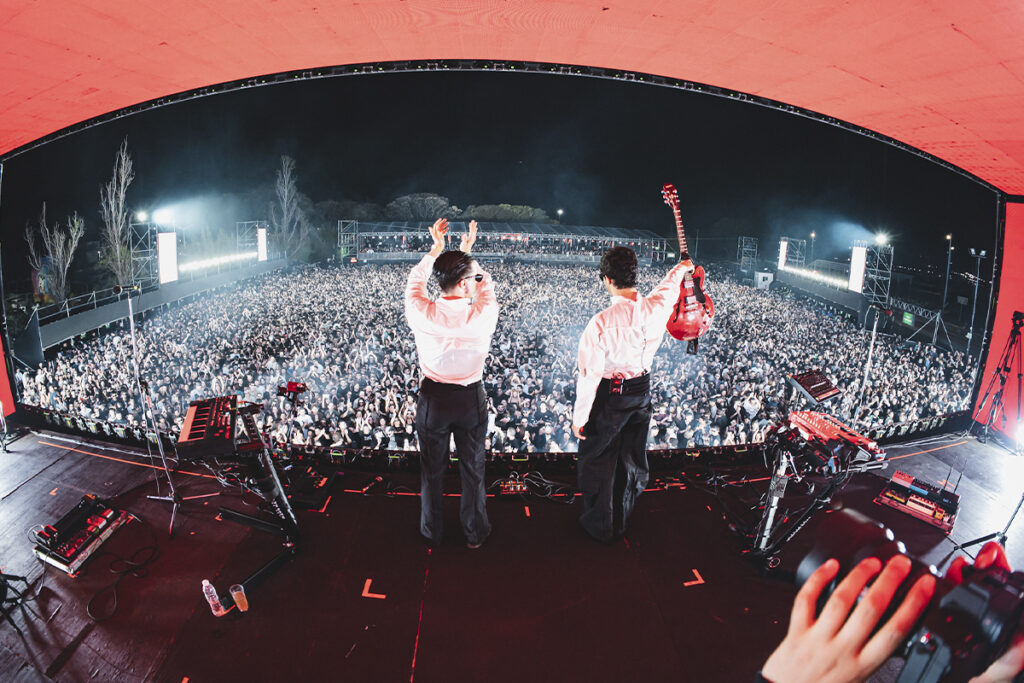 Peces Raros en vivo frente a una multitud, combinando electrónica y rock en un show masivo que refleja el cruce entre vanguardia y pista de baile.