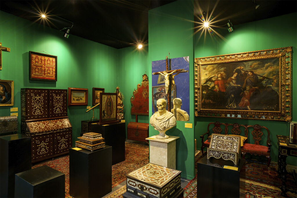 Vista del Salón del Anticuario con obras religiosas, muebles antiguos y pinturas exhibidas en Zona Maco.