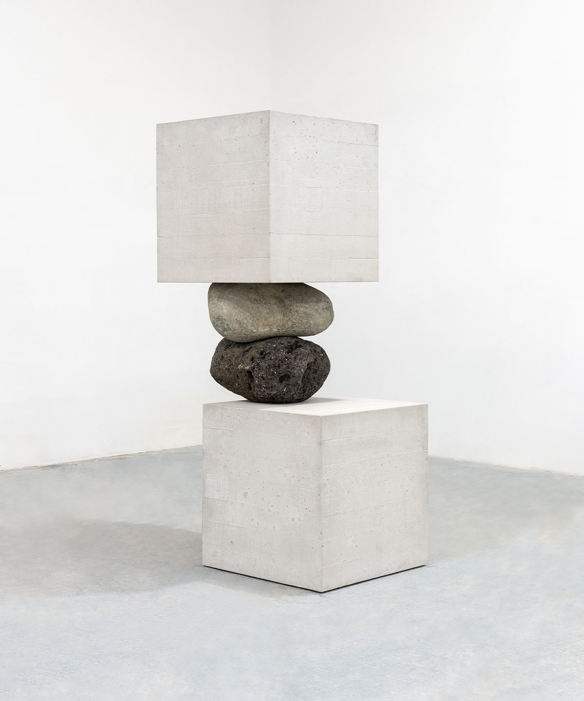 Escultura de Jose Dávila con bloques de concreto y piedras volcánicas en equilibrio.