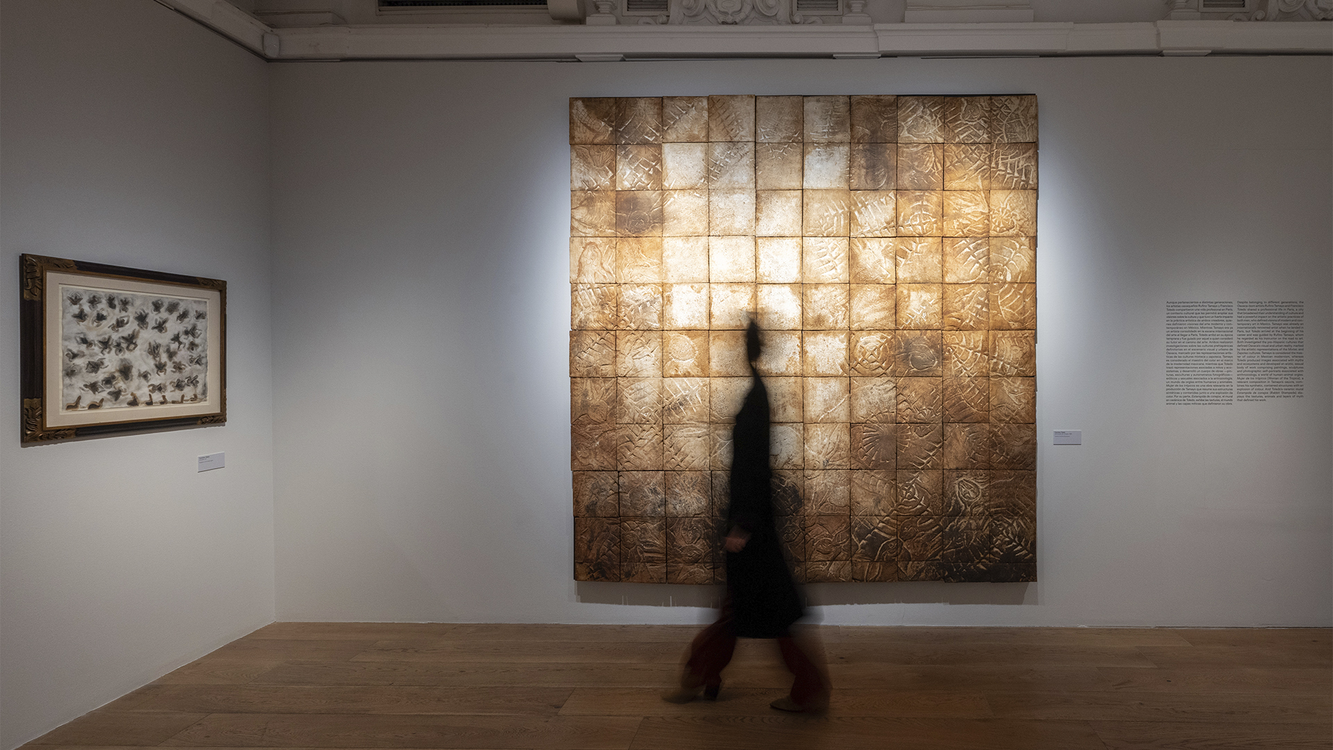 Visitante frente a una gran obra abstracta en una exposición de arte mexicano en Madrid.