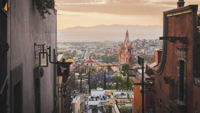 Vista de San Miguel de Allende con la Parroquia de San Miguel Arcángel al atardecer entre calles coloniales