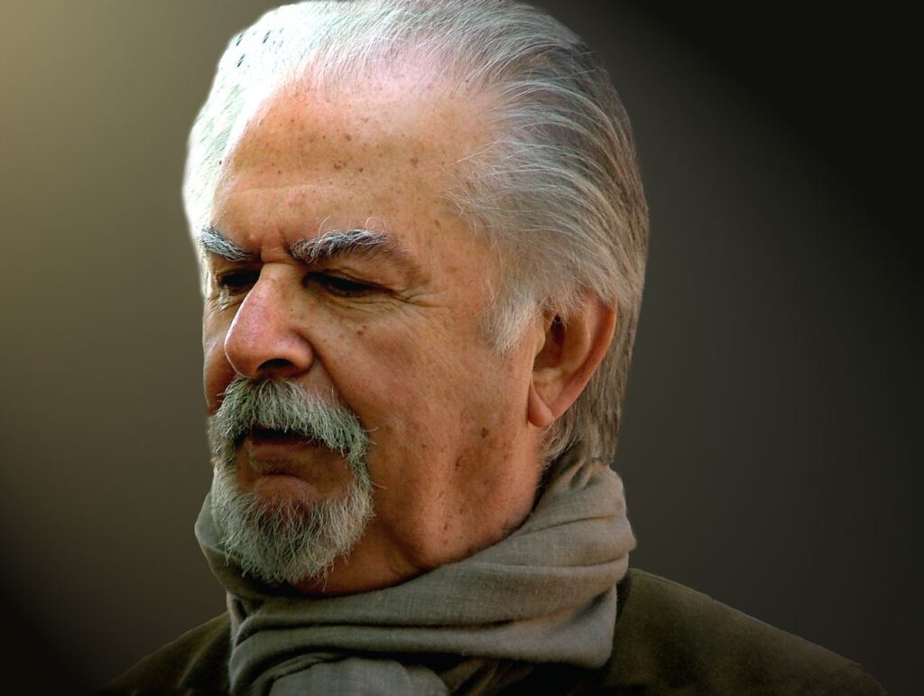 Retrato de Fernando Botero, artista colombiano, con cabello blanco, barba y bufanda.