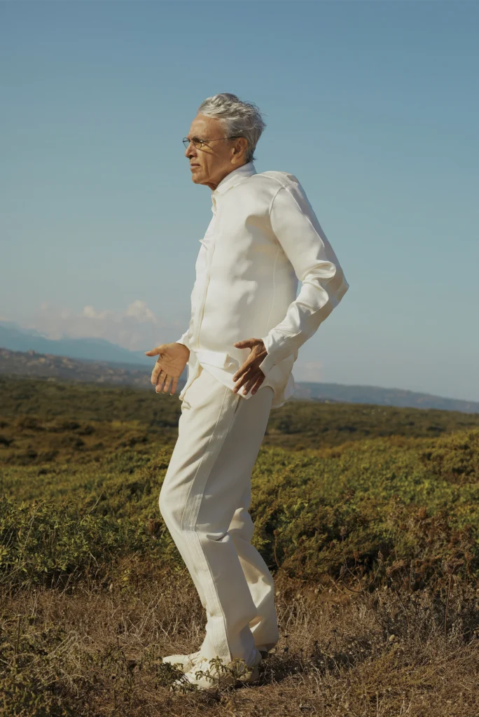 Caetano Veloso retratado por Cecilia Duarte en un paisaje natural con estilismo blanco y luz cálida.