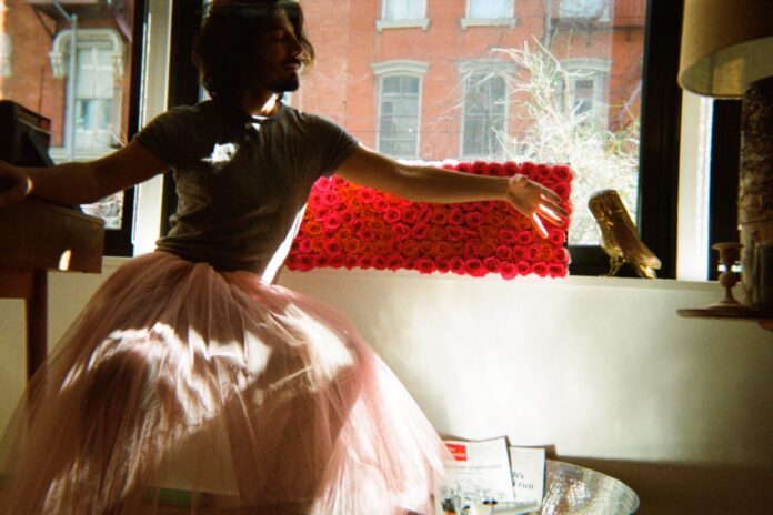 Amulio Espinosa posa frente a una ventana con una falda de tul rosa durante una sesión artística en un departamento de Nueva York. Foto: cortesía del artista.