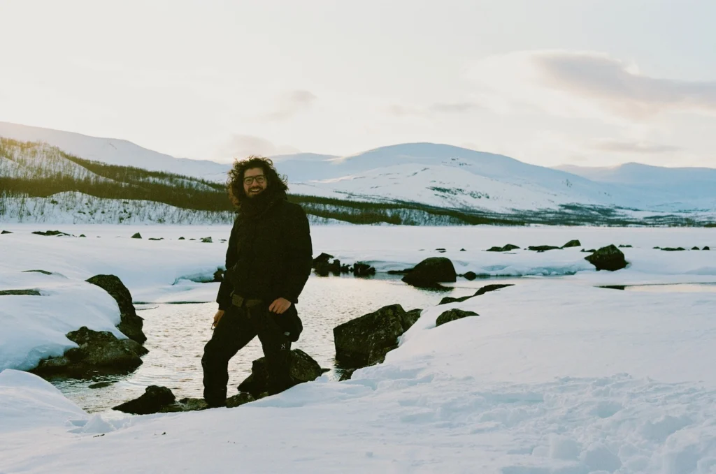 Amulio Espinosa posa en un paisaje nevado del norte de Finlandia, rodeado de montañas y lagos congelados. Foto: cortesía del artista.