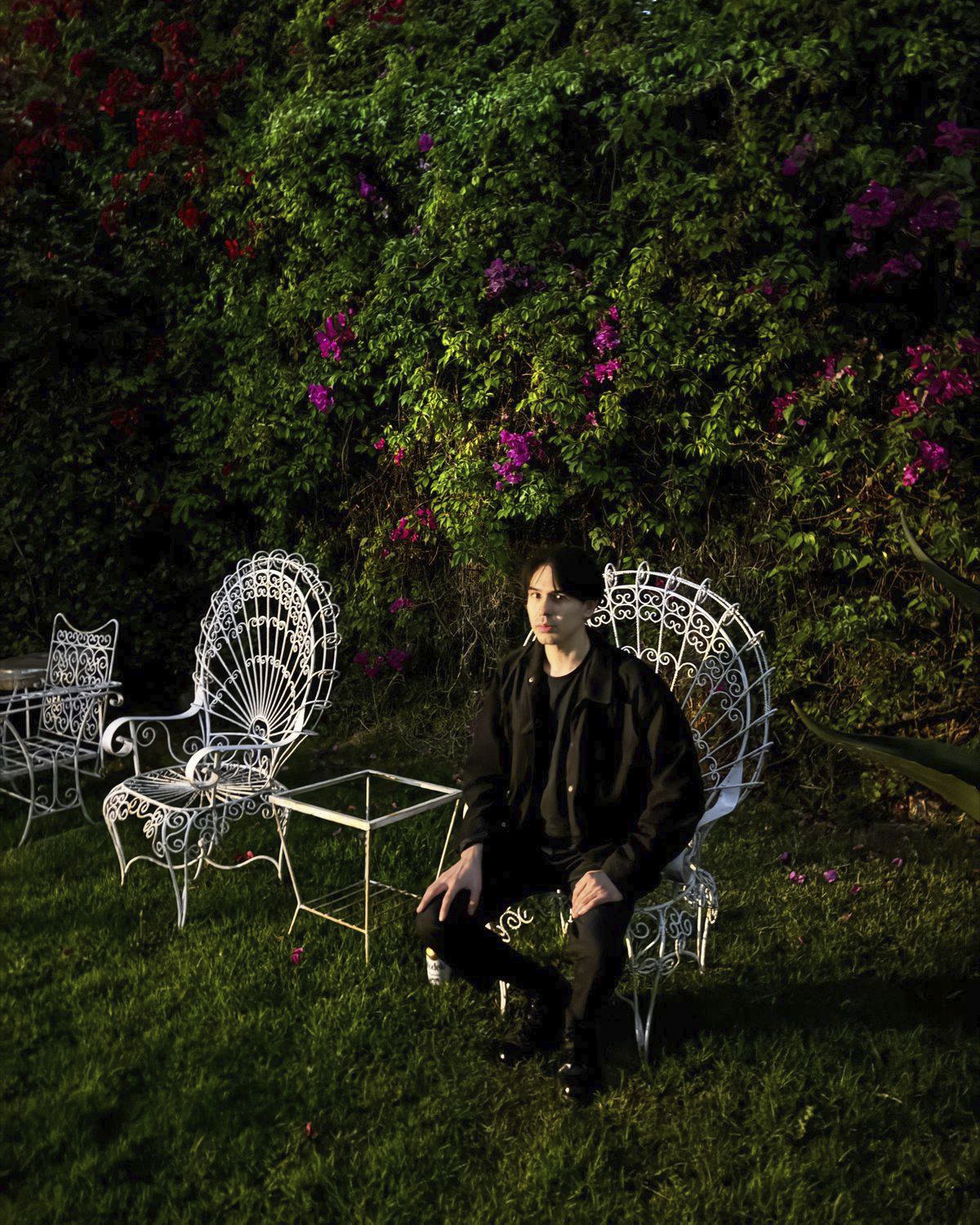 Retrato ambiental de Rogelio Serrano en un jardín rodeado de flores y vegetación