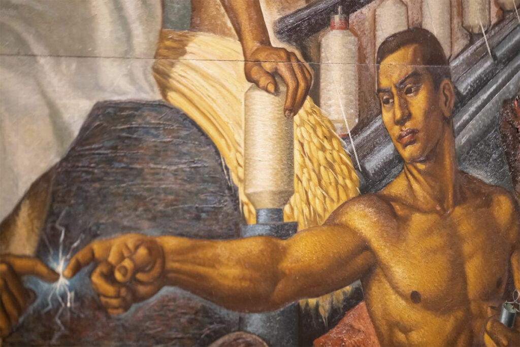 Detalle de un mural de Roberto Montenegro que muestra dos figuras masculinas extendiendo sus manos hasta tocarse mediante una chispa luminosa, rodeadas de símbolos de industria, ciencia y trabajo.