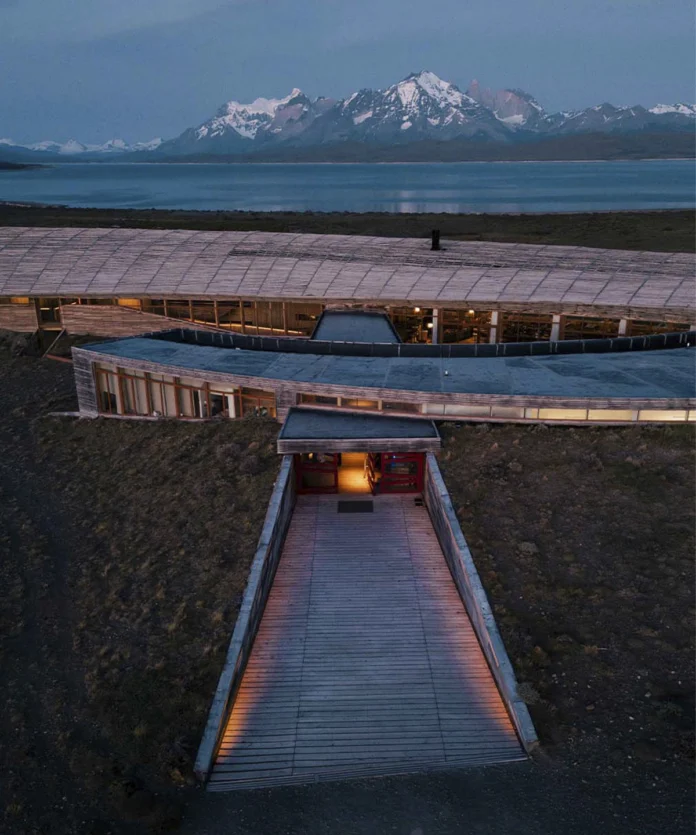 Vista panorámica de Tierra Patagonia al atardecer con las montañas iluminadas por los últimos tonos del día.