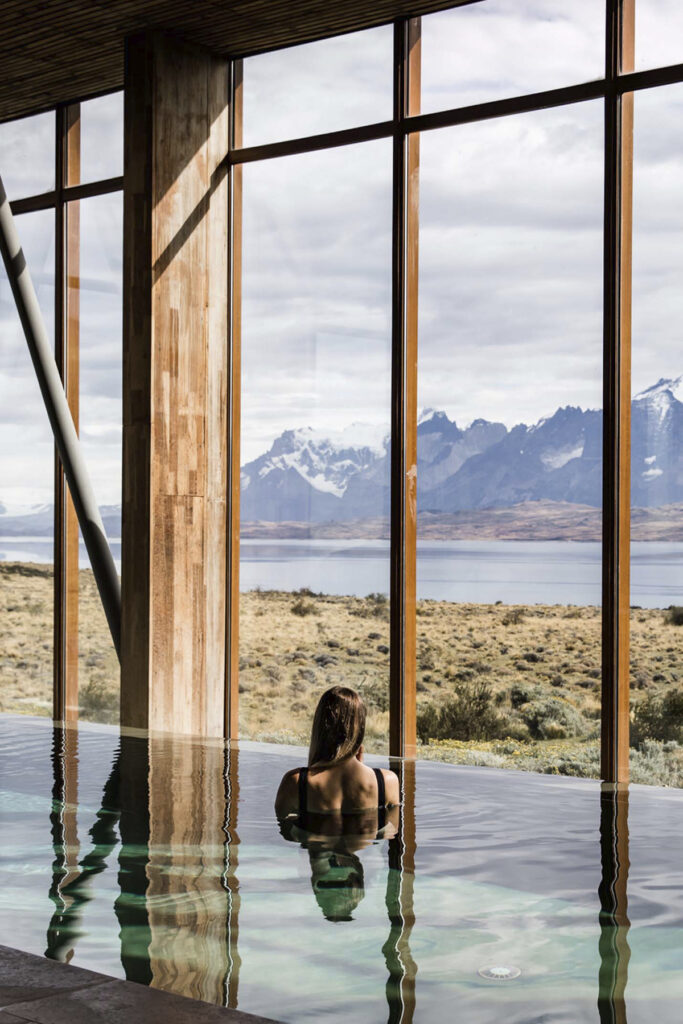 Sala de tratamiento con revestimientos de madera y ventana orientada al paisaje exterior.