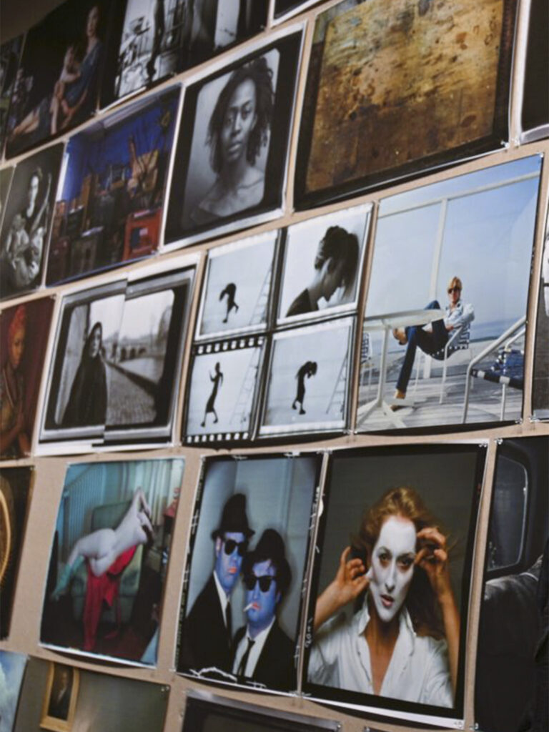 La imagen muestra una cuadrícula de fotografías de diversos formatos y temáticas. Entre ellas destacan retratos de personalidades de la cultura popular, escenas documentales y trabajos editoriales que ilustran la amplitud de la trayectoria profesional de Leibovitz y su influencia en la fotografía contemporánea.