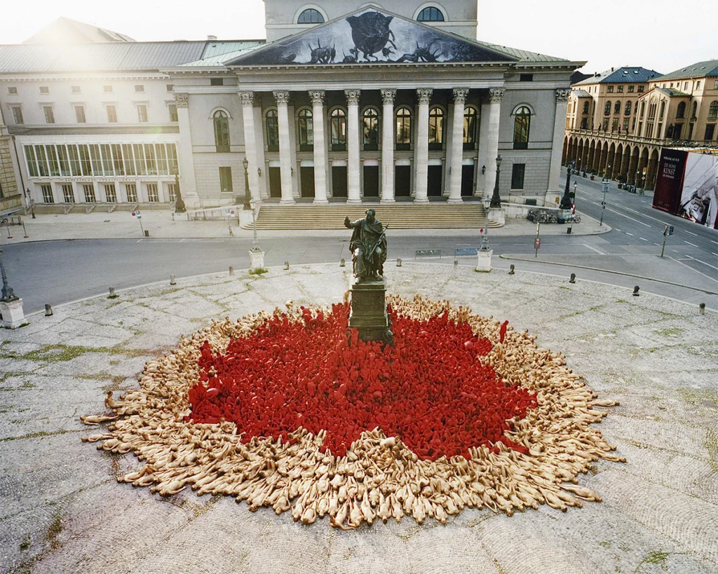 Instalación artística de Spencer Tunick con cientos de personas desnudas formando una composición circular en Múnich, Alemania.