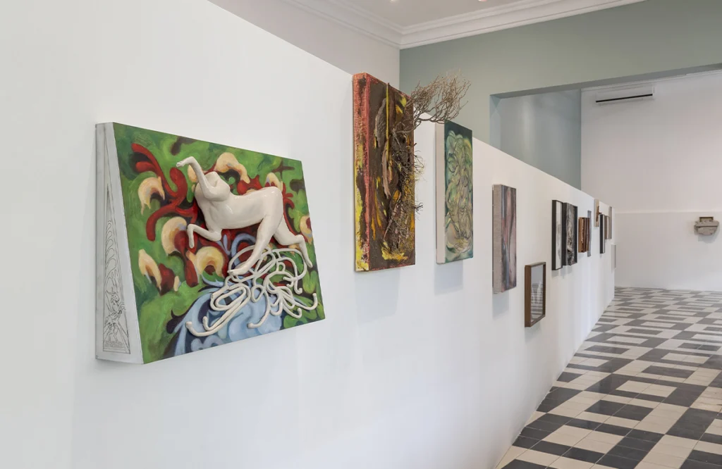 Vista de una sala de exposición con pinturas y esculturas contemporáneas instaladas en un recorrido curatorial.