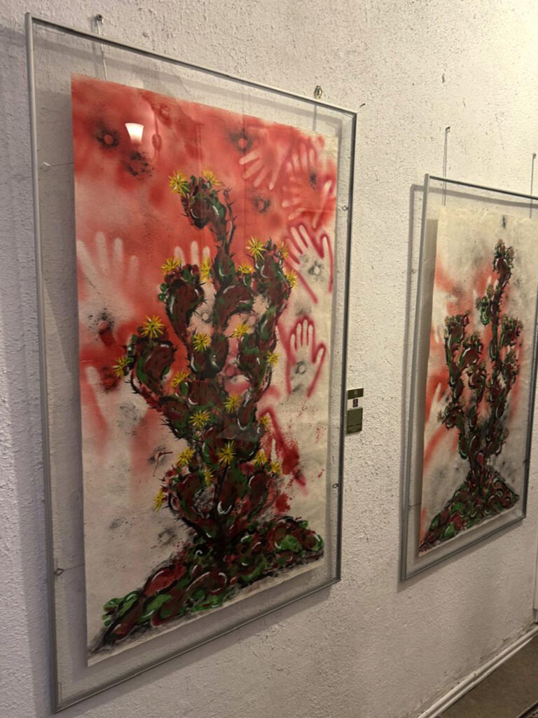 Pinturas de cactus expuestas en una galería.