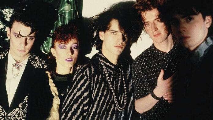 The five members of Fricción pose together in a band photo.