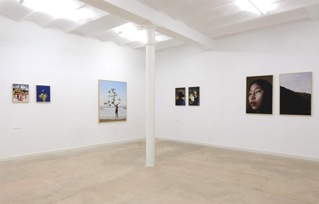 Vista general de una sala con varias fotografías enmarcadas instaladas sobre muros blancos.