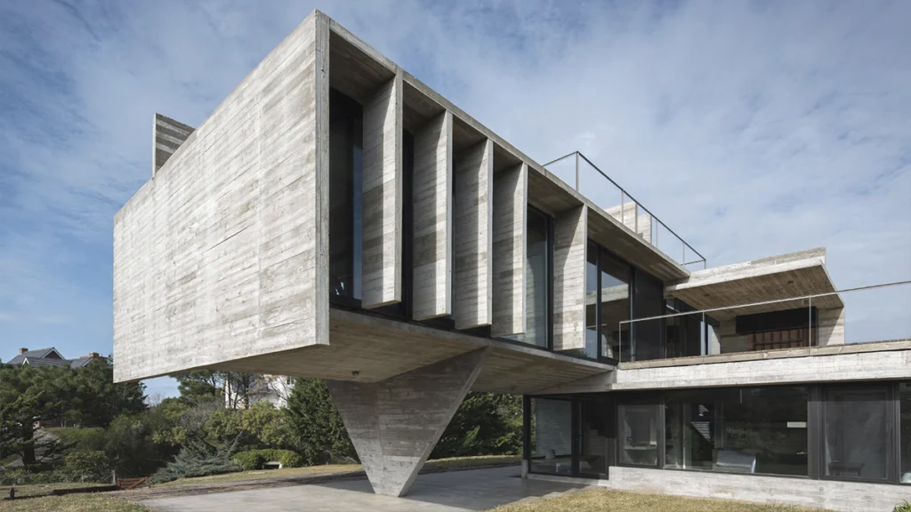 Casa de Luciano Kruk con gran volumen de hormigón en voladizo y fachada acristalada.