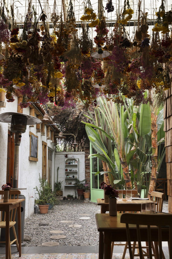 Comedor de Pulpería Santa Elvira decorado con flores secas, vajilla artesanal y mobiliario de madera.