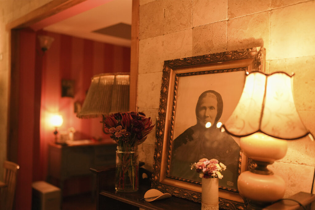 Salón de Pulpería Santa Elvira con iluminación cálida, retratos antiguos y decoración de inspiración doméstica.