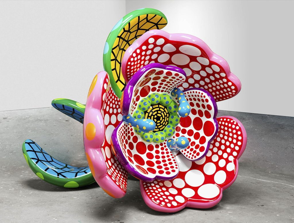 Escultura de Yayoi Kusama con formas florales y orgánicas de colores intensos, cubierta con patrones de lunares.