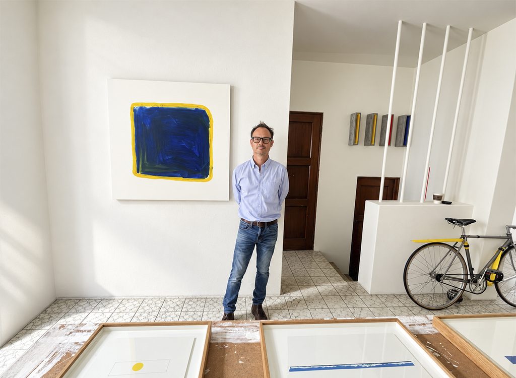 Retrato del artista Francisco Ugarte posando de pie en su luminoso estudio.