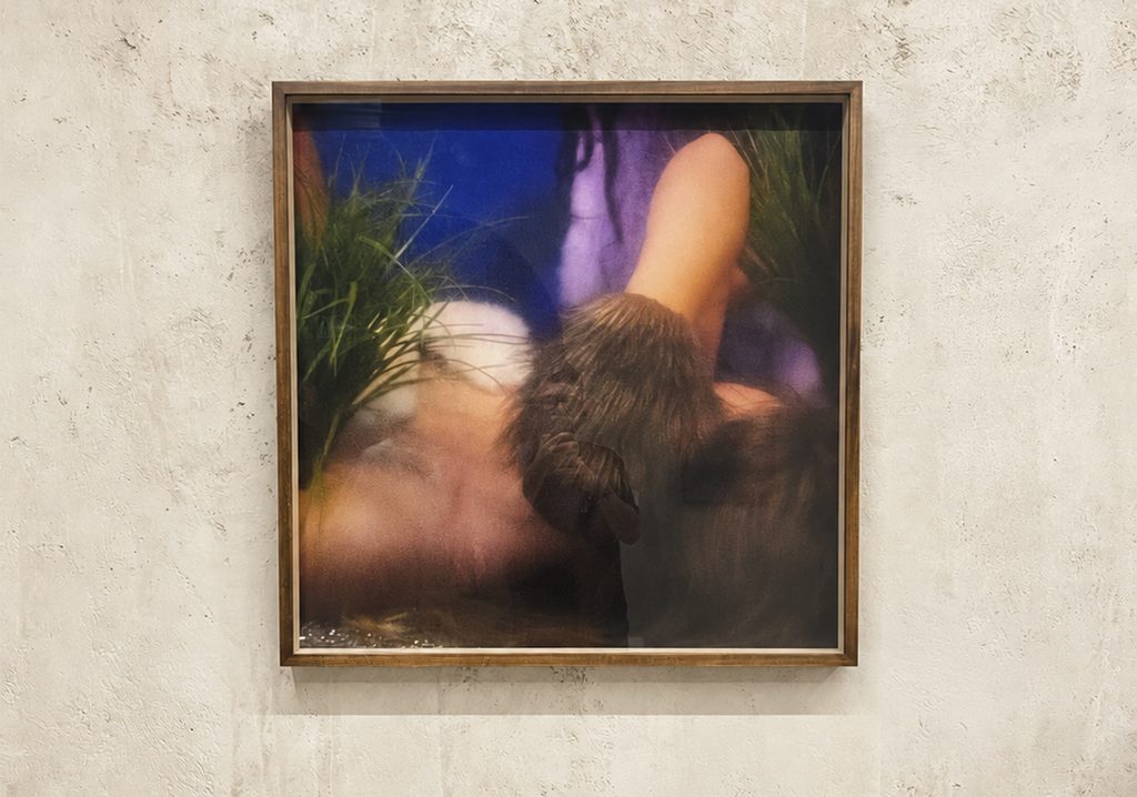Fotografía artística enmarcada en madera con tonos azules y texturas orgánicas expuesta en muro neutro.