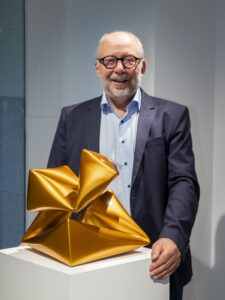 Persona junto a una escultura amarilla en una fotografía publicada para Color Cosmos, de Willi Siber, por Gerhardt Braun Gallery.