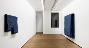 Vista de sala de Blue and Black Puncture Paintings, de Simon Callery, con dos obras azules perforadas en Rafael Pérez Hernando.