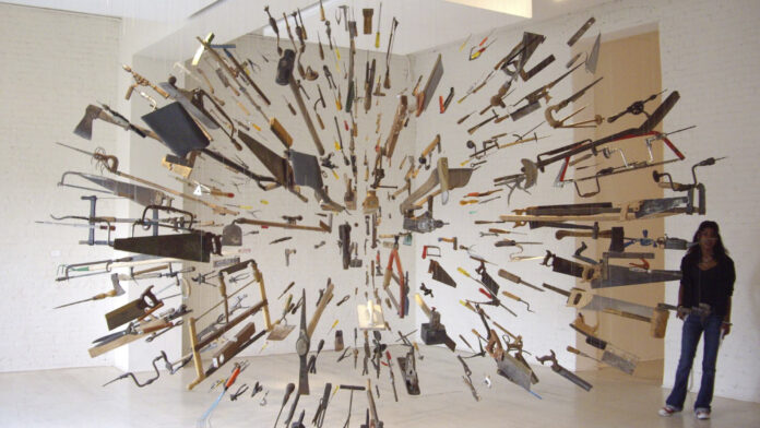 An installation by Damián Ortega consisting of saws, hammers, shovels, axes, and other tools suspended in the shape of an explosion.