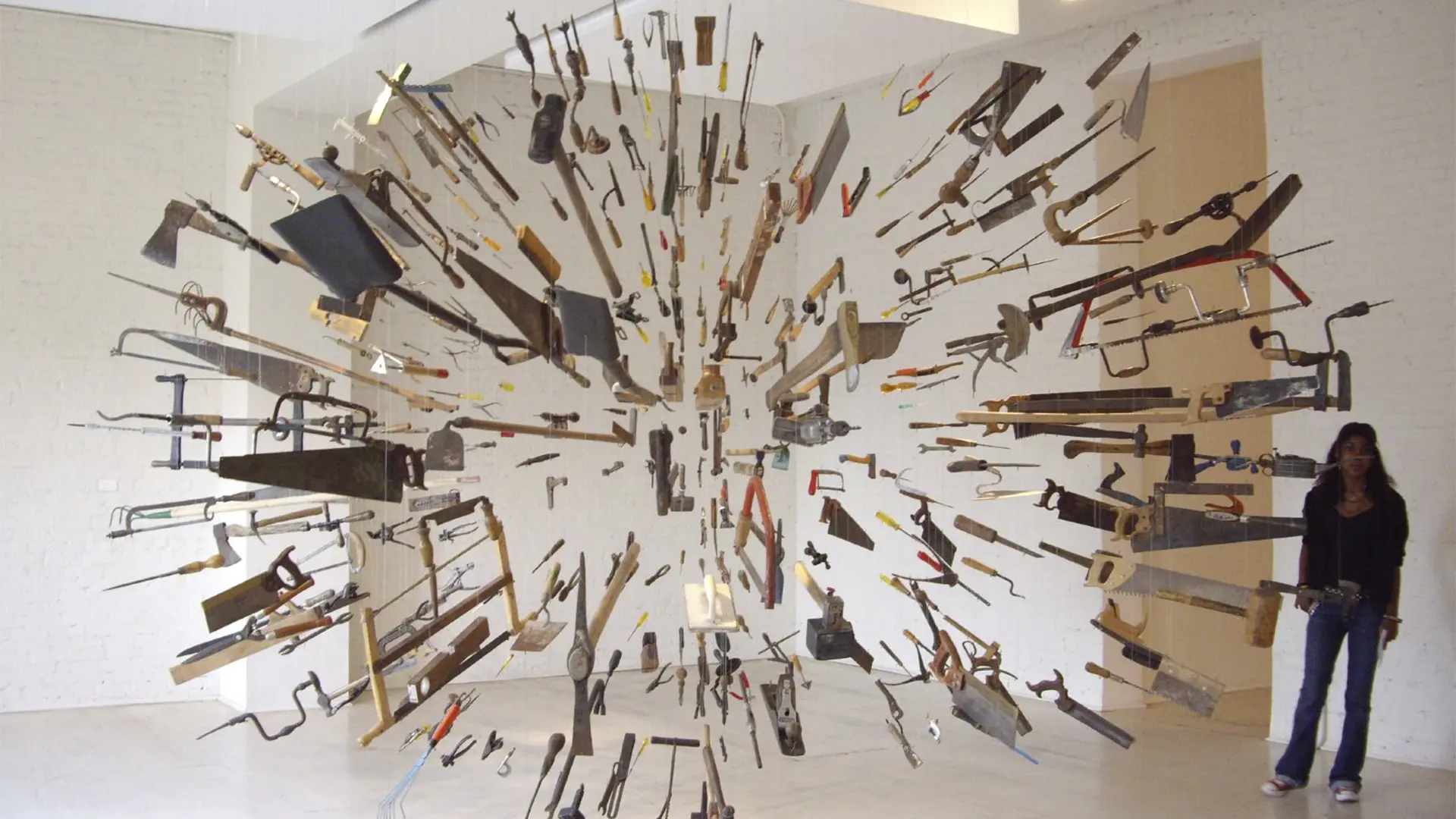 An installation by Damián Ortega consisting of saws, hammers, shovels, axes, and other tools suspended in the shape of an explosion.