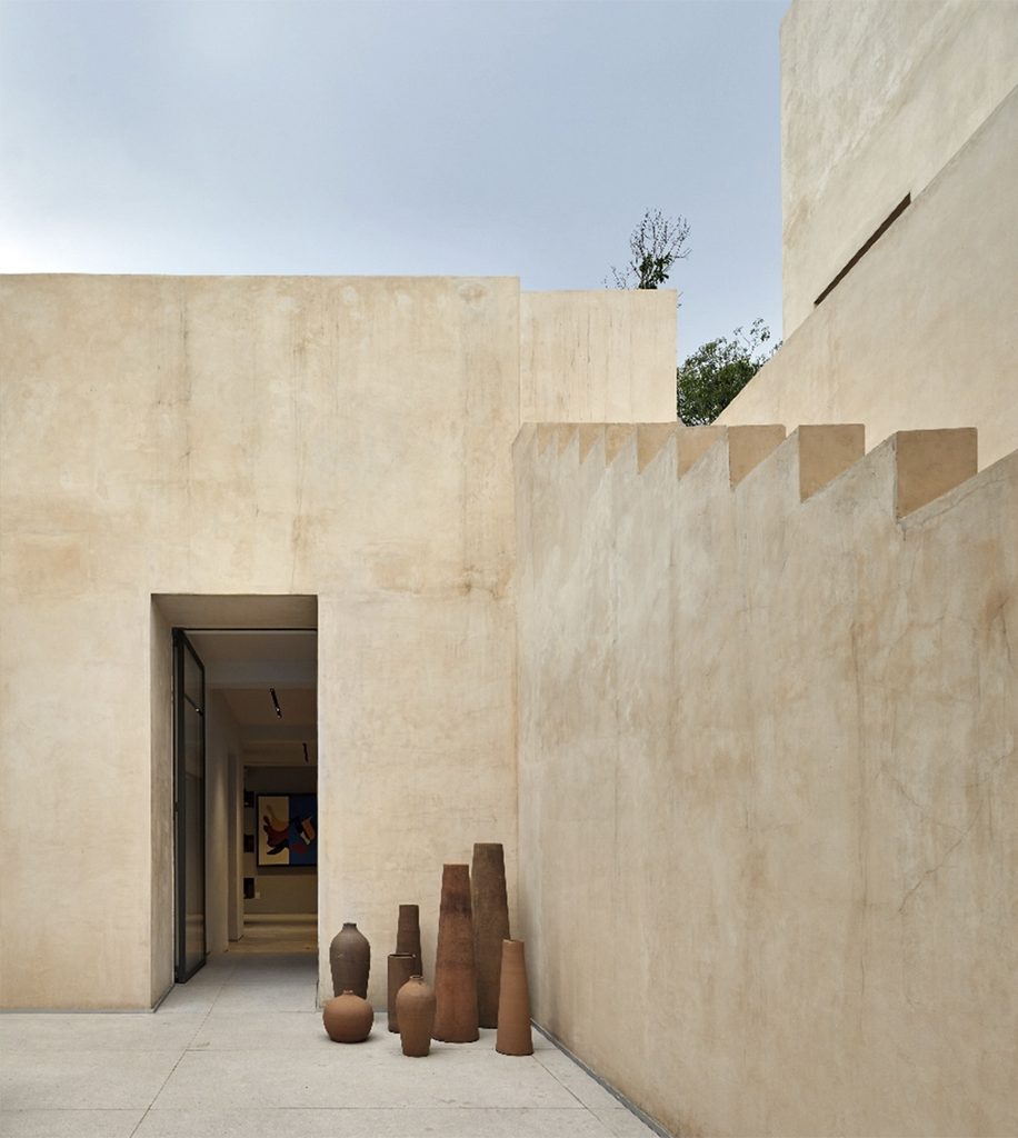 A courtyard with light-colored walls and ceramic tiles at CASA HOTBOOK, Mexico City