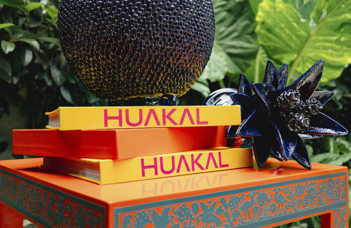 Libros de Huakal sobre mesa con artesanías