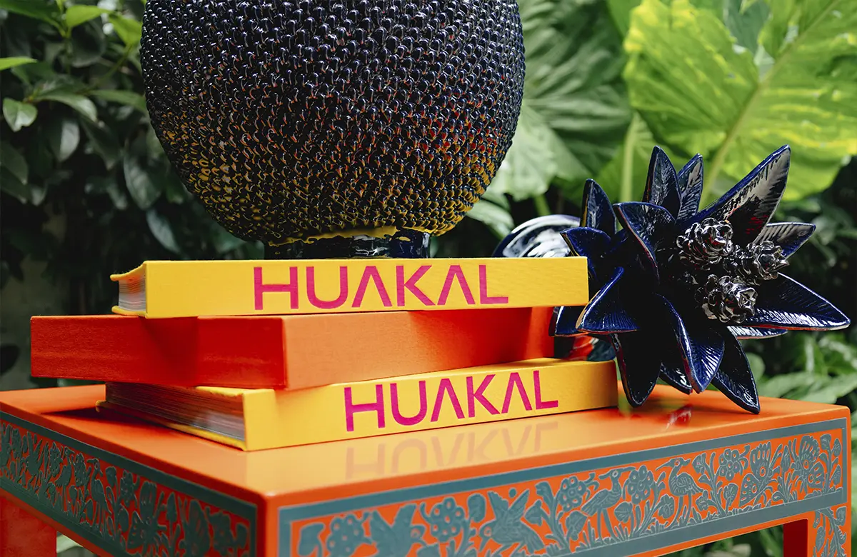 Libros de Huakal sobre mesa con artesanías