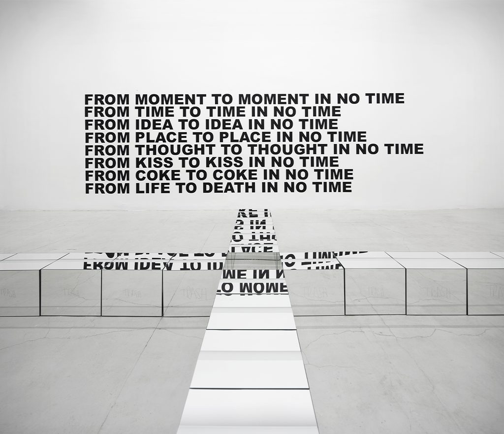 Text-based installation by Stefan Brüggemann featuring black phrases and reflective surfaces