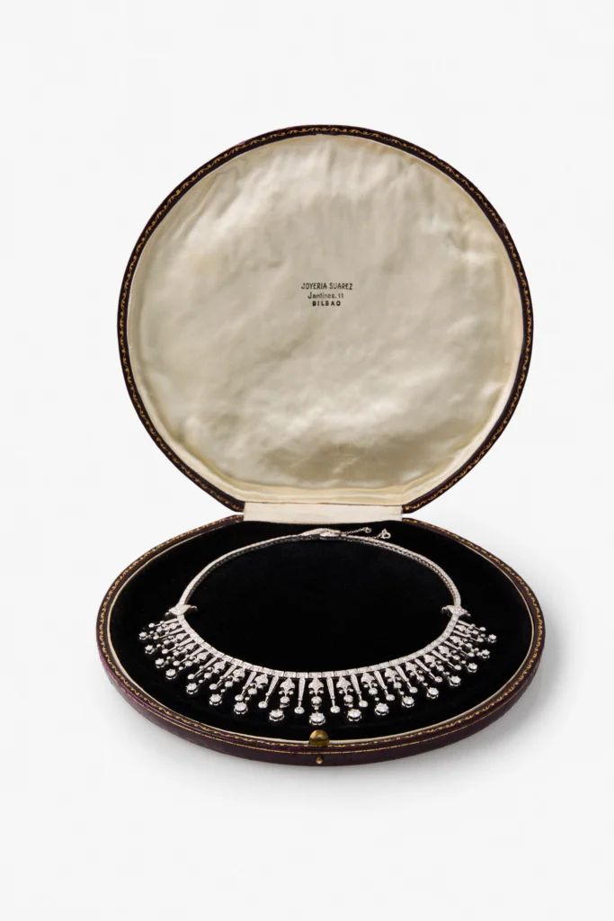 Collar de diamantes dispuesto en un estuche antiguo con la inscripción Joyería Suárez, Jardines 11, Bilbao.