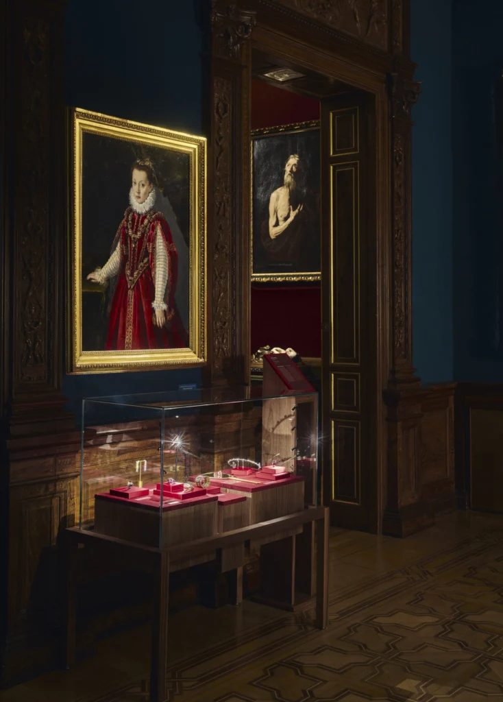 Retrato de una mujer con vestido rojo junto a una vitrina con joyas de Suárez en una sala del Museo Lázaro Galdiano.