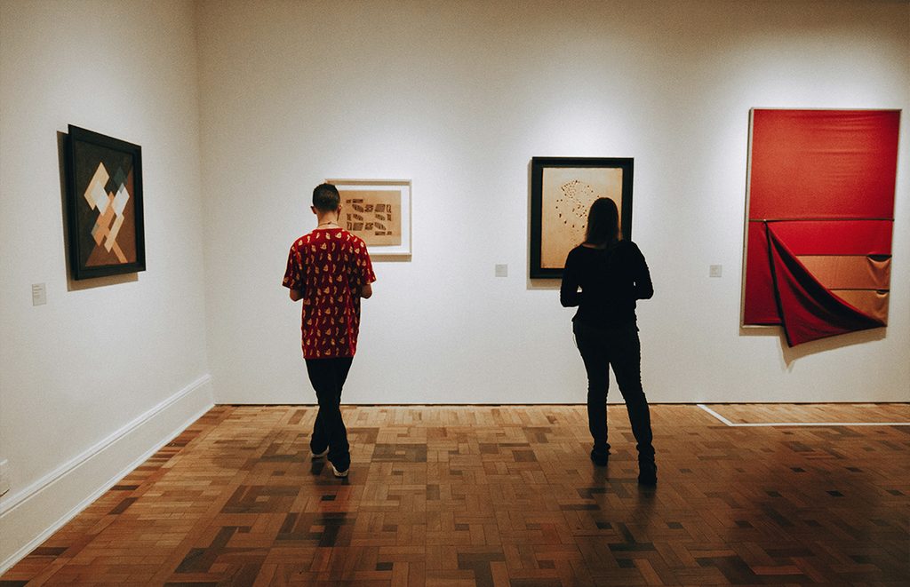 Dos personas observan obras en una galería.