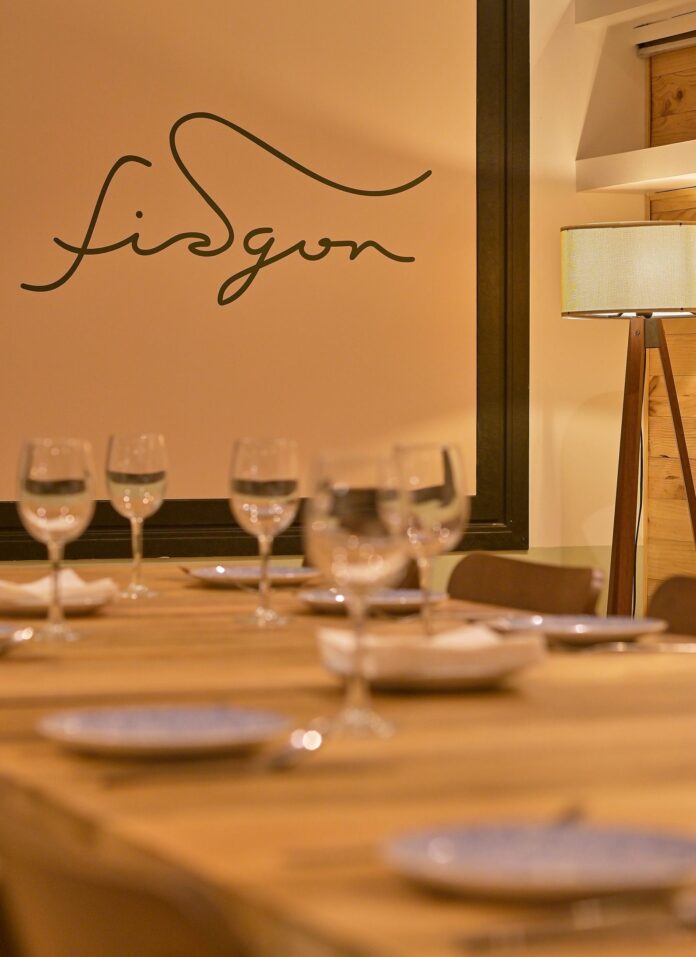 Mesa preparada en el comedor de Fisgón delante del logotipo.